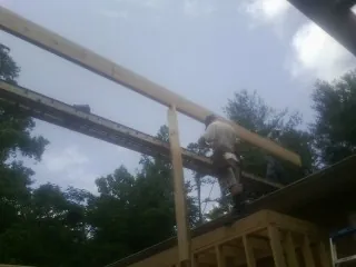 Carpenter setting a ridge beam over a new addition frame — Ice Dam Removal by Roofing Brothers in Lansford