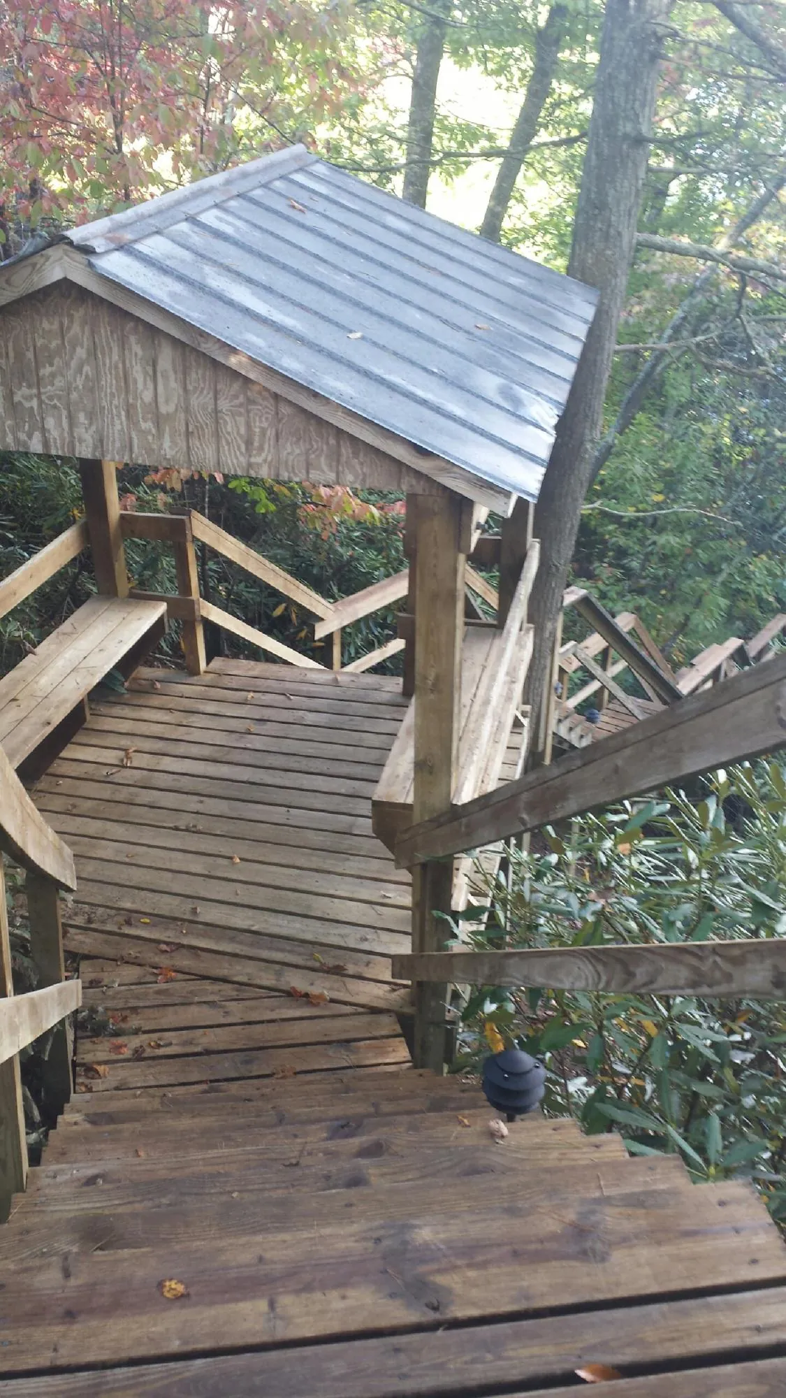 Metal roofed shelter over wooden steps on a wooded walkway — Skylight Repair & Installation work by our crew in Lansford